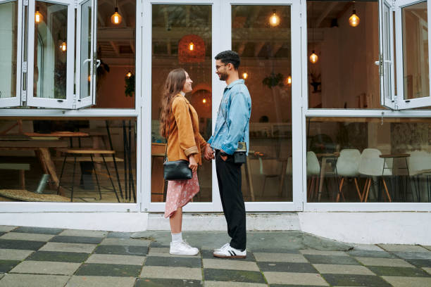 Man and woman standing face to face, gazing closely at each other